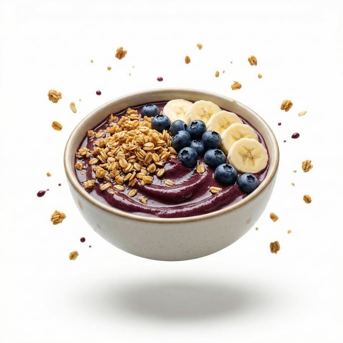 A bowl of açaí topped with granola, banana slices, and blueberries