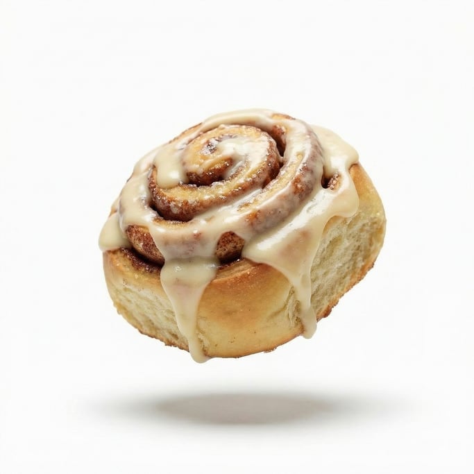 A fresh cinnamon roll with cream cheese icing, floating in mid-air at a slight angle