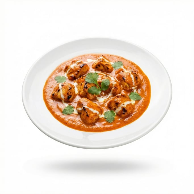 A plate of chicken tikka masala with vibrant orange sauce, floating in mid-air