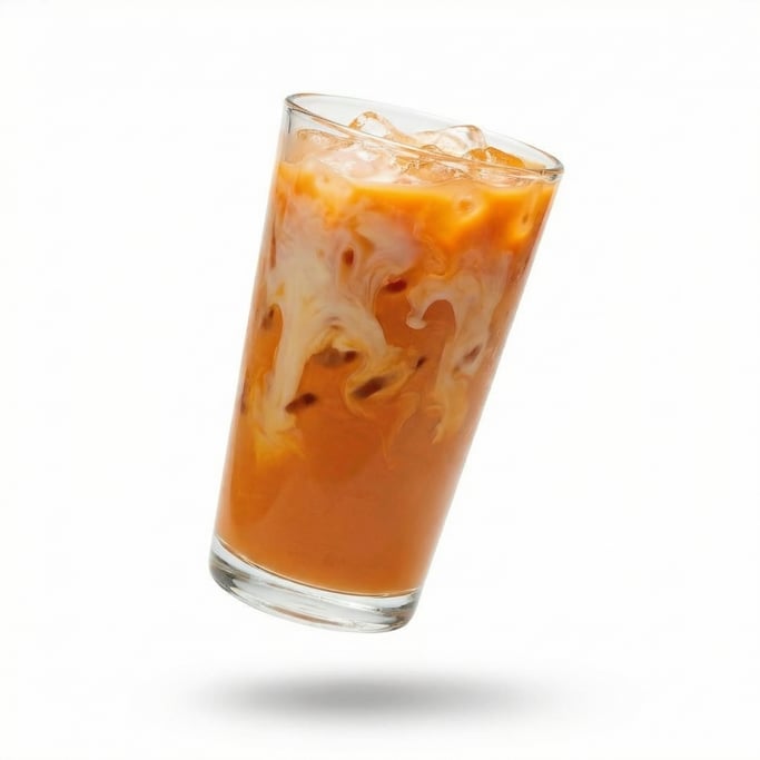 A glass of Thai iced tea with condensed milk swirling through orange tea