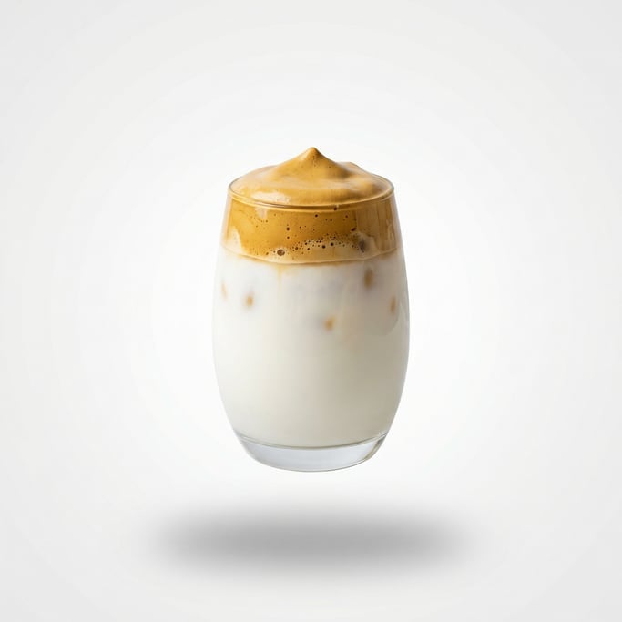A glass of dalgona whipped coffee over iced milk, floating in mid-air