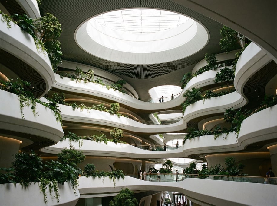 A futuristic building interior atrium with organic flowing balconies in white composite