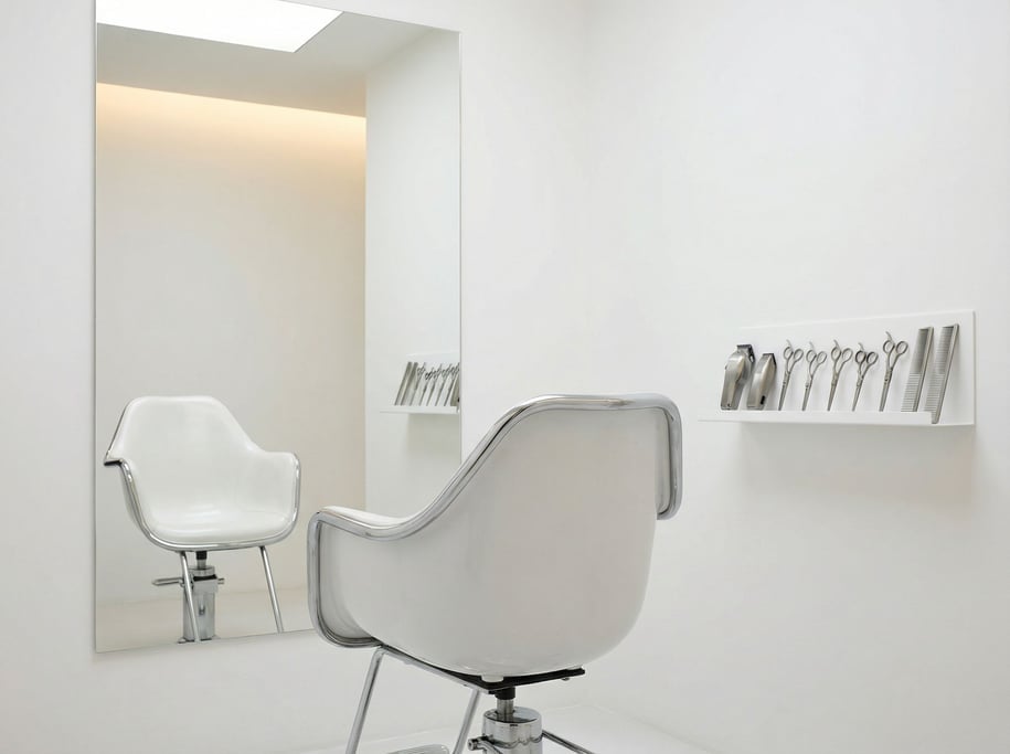 A barber's chair — vintage chrome frame but with a modern white composite seat — sits in the center