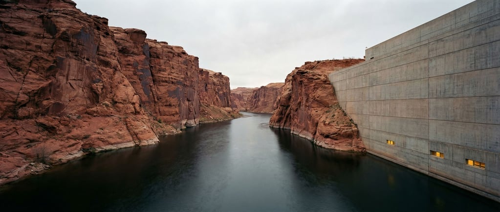 Ultra-wide shot of a river flowing through a narrow canyon, the water dark and slow