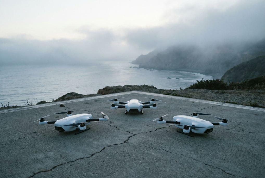 Three autonomous drones at rest on a concrete landing pad