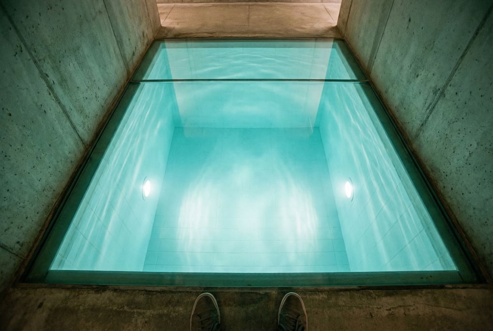 A submerged space visible through a glass floor — beneath the viewer's feet