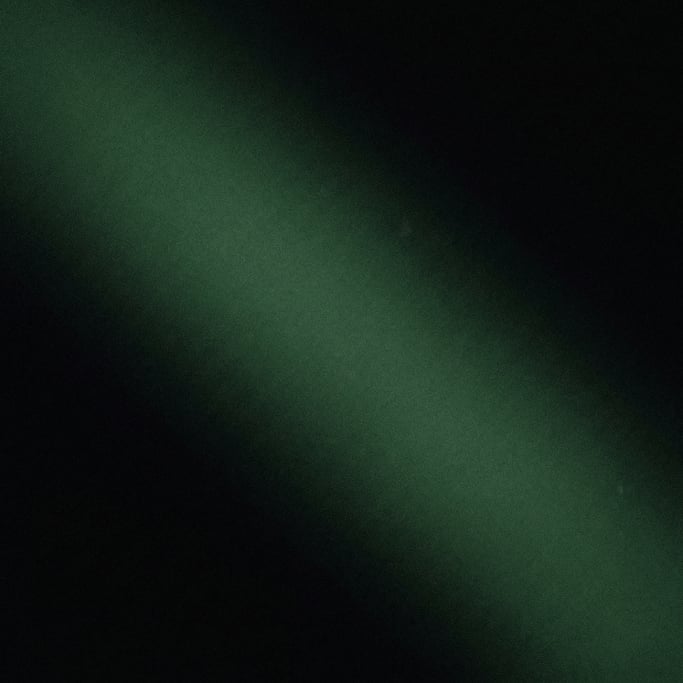 Moody dark gradient atmosphere, deep black background with a diagonal band of deep forest green ligh