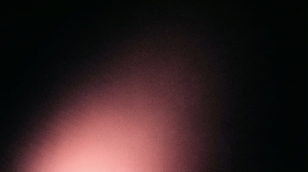 Moody dark gradient atmosphere, deep black background with a single soft glow of warm rose-pink at t