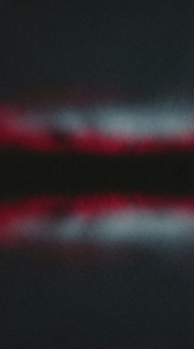 Moody film grain gradient, charcoal background with two soft parallel bands of deep ruby and cool pe