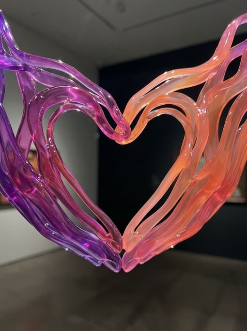 Two hands forming a heart shape rendered as abstract flowing ribbon forms