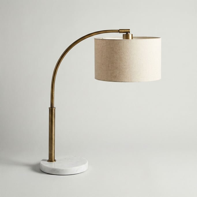 Mid-century brass arc desk lamp with a natural linen drum shade and a weighted circular marble base