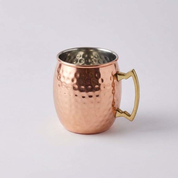 Copper Moscow mule mug with an all-over hammered surface finish, brass handle