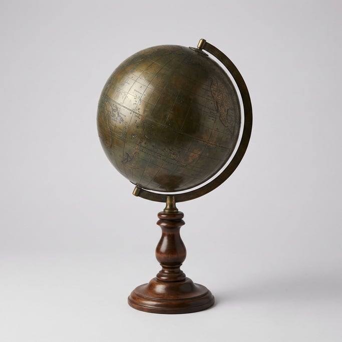Antique brass desktop globe with a patinated oxidized surface, engraved meridian lines