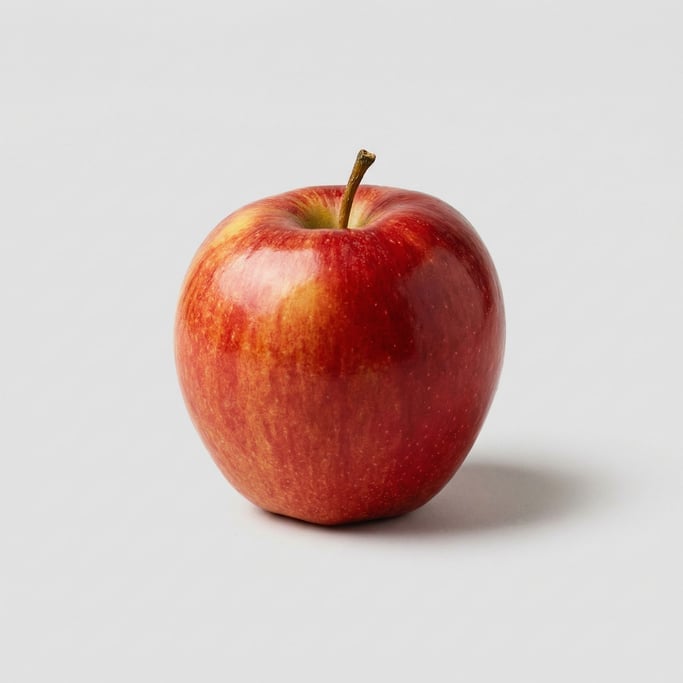 Single ripe red apple with glossy crimson-and-golden blushed skin, a short brown stem
