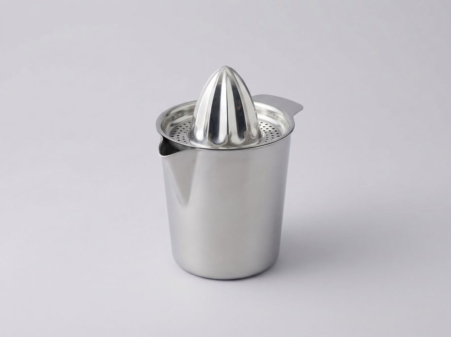 Stainless steel citrus juicer with a tall conical reamer, integrated strainer spout