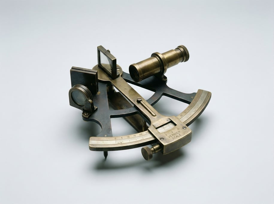 Vintage brass sextant with a patinated graduated arc, folding telescope sight