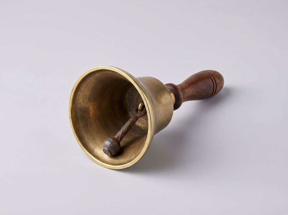 Antique brass hand bell with a turned dark walnut handle, polished rim