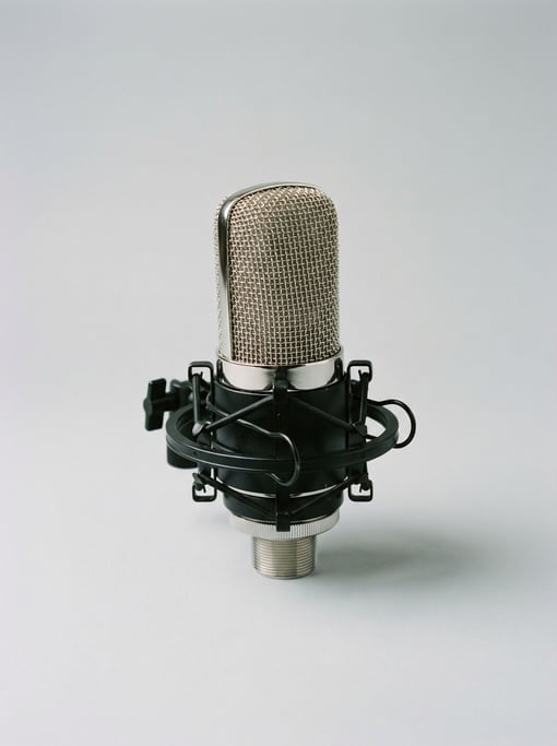 Standing condenser microphone with a chrome wire-mesh grille head, elastic shock mount ring