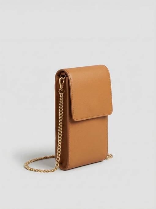 Leather crossbody phone case in camel-colored full-grain hide with a slim gold curb-chain strap and