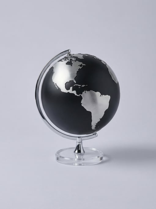 Desktop globe in matte black with raised brushed silver continent outlines, a chrome meridian ring
