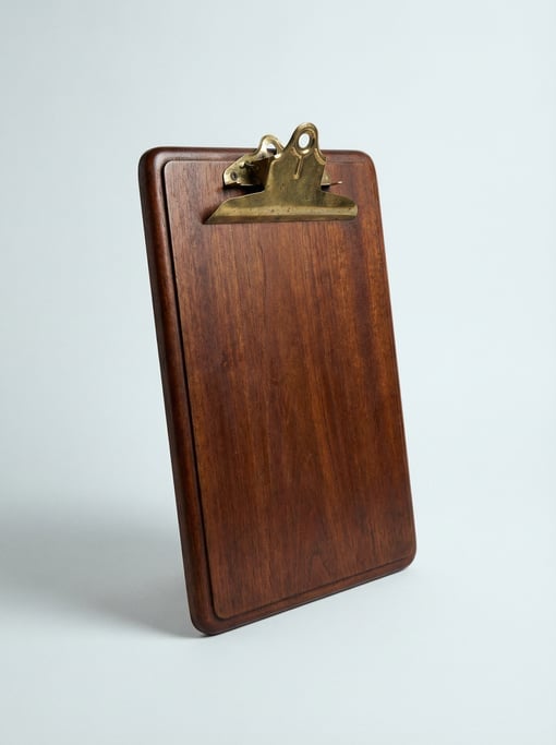 Vintage clipboard in dark mahogany hardwood with a heavy spring-loaded brass clip and rounded bevele