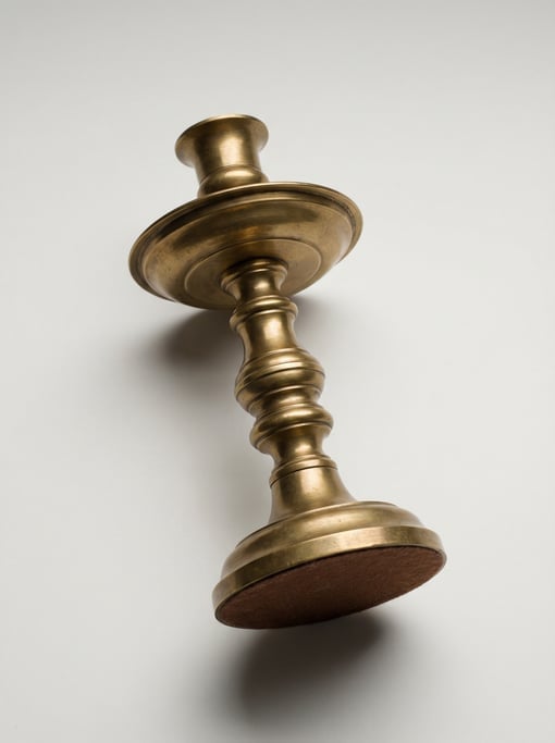 Vintage brass candlestick with a wide drip tray, turned baluster column