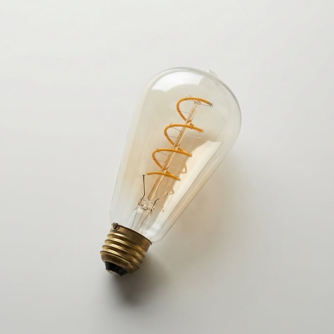 Oversized Edison light bulb with a visible glowing amber spiral filament, tear-drop glass shape