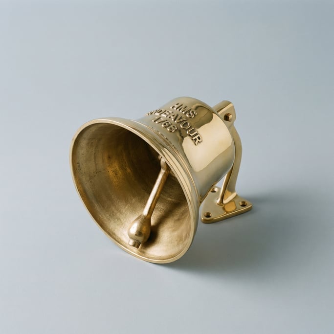 Polished brass ship bell with a clapper tongue inside, cast lettering on the crown