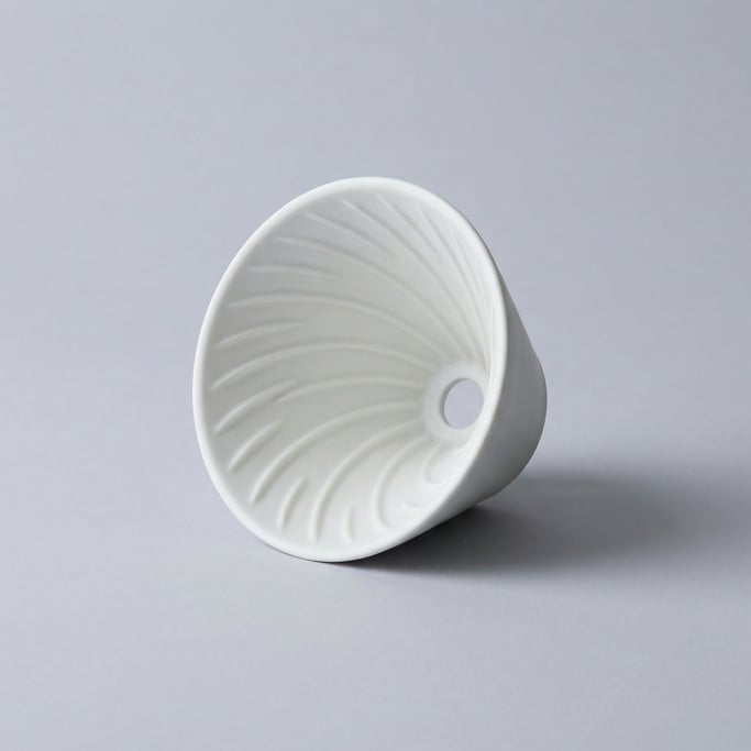 Ceramic pour-over coffee dripper in matte white porcelain with a conical shape