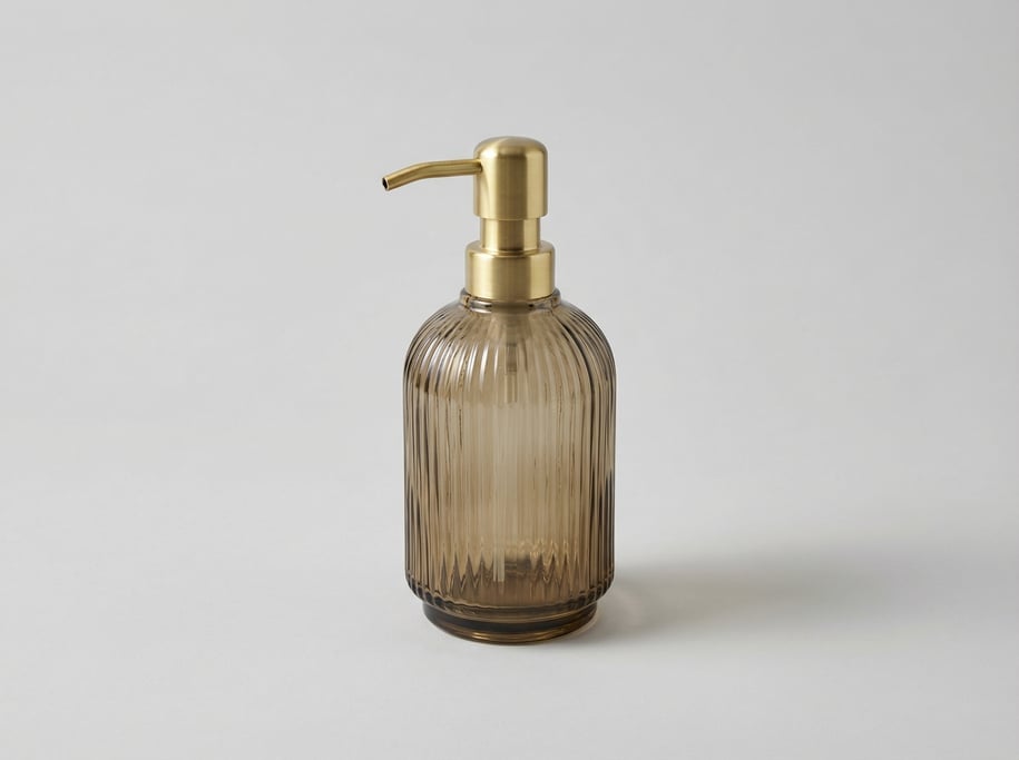 Glass soap dispenser in smoky amber with a polished brass pump head, ribbed glass body