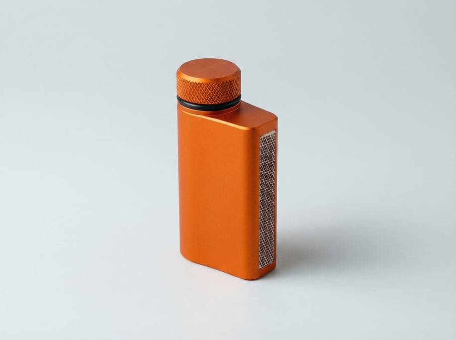 Waterproof match case in anodized orange aluminum with a threaded screw cap, O-ring seal