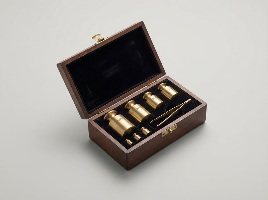 Brass analytical balance weight set in a velvet-lined wooden case with six polished cylindrical weig