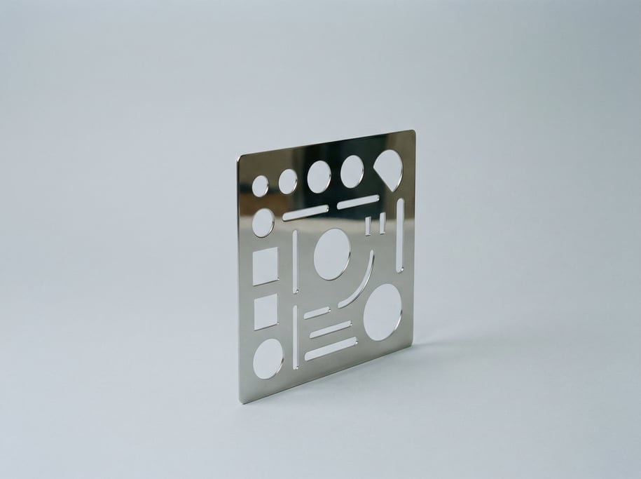 Drafting erasing shield in thin stainless steel with various shaped cutout windows and a mirror-poli