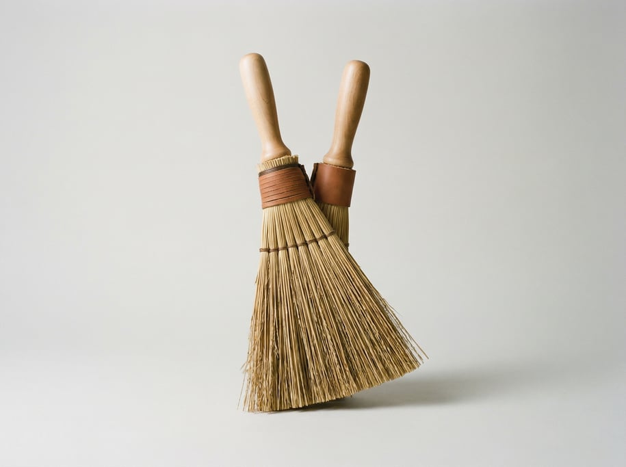 Wooden whisk broom in natural broomcorn straw with a bound leather collar
