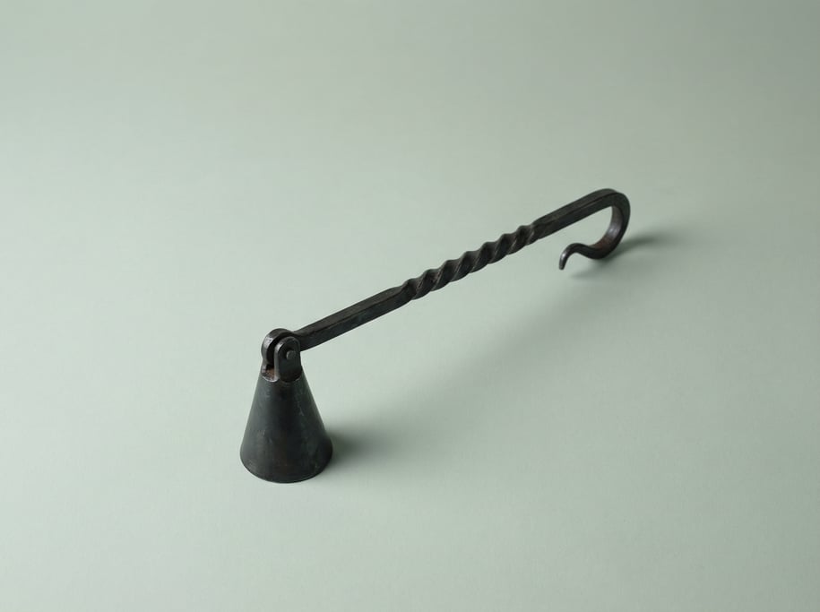 Hand-forged wrought iron candle snuffer with a cone-shaped extinguisher cap, twisted handle shaft
