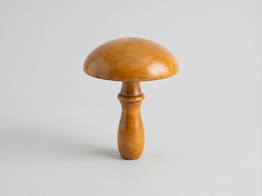 Vintage wooden darning mushroom with a smooth domed cap, turned handle shaft