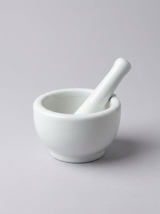 Porcelain pill mortar in glossy white with a deep rounded grinding bowl, flat base