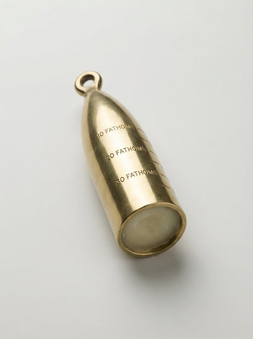 Brass sounding lead weight in a torpedo shape with a tallow cup at the base, a line attachment eye