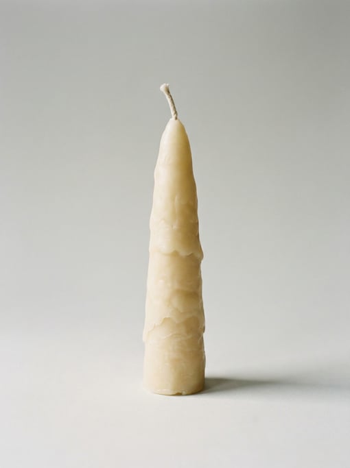 Tallow dip candle in natural cream beeswax with a visible cotton wick