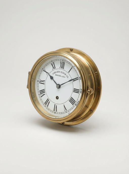 Brass ship's clock with a white enamel dial, raised chapter ring, a beveled glass bezel