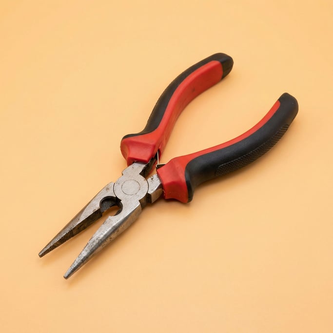 Needle-nose pliers with red and black rubber handles, slight overhead angle