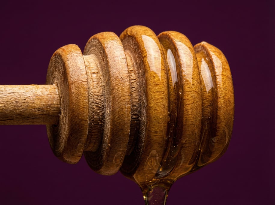 Wooden honey dipper with spiral grooves, studio macro lighting revealing the turned wood detail