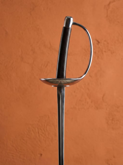 Fencing foil with a French grip and chrome guard, studio rim light tracing the blade