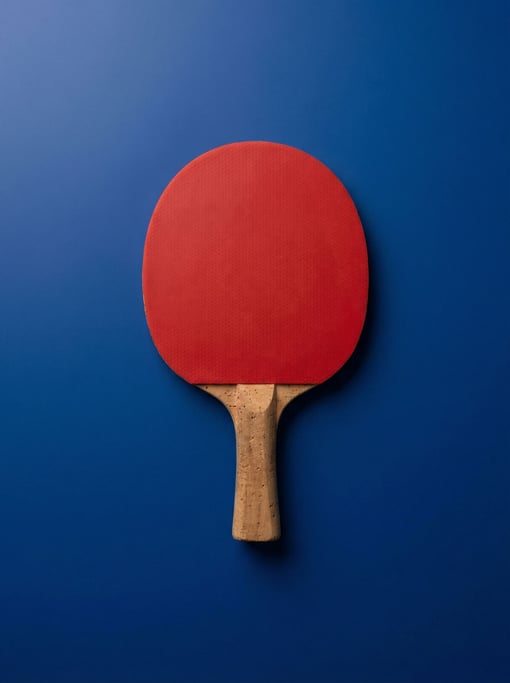 Table tennis paddle with a red rubber face and cork handle