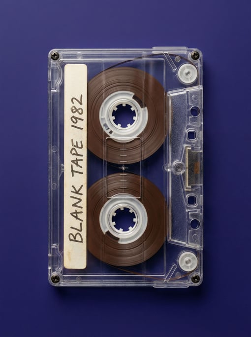 Compact cassette tape in transparent shell revealing the brown magnetic tape inside