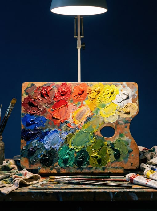 Wooden artist palette with dried paint remnants in vivid colors