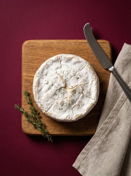 Small wheel of aged Brie cheese with a white rind