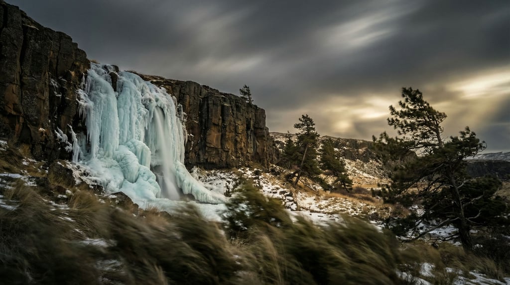 A frozen waterfall cascading down a basalt cliff face, ice formations in pale blue and white (qbbmoglm)