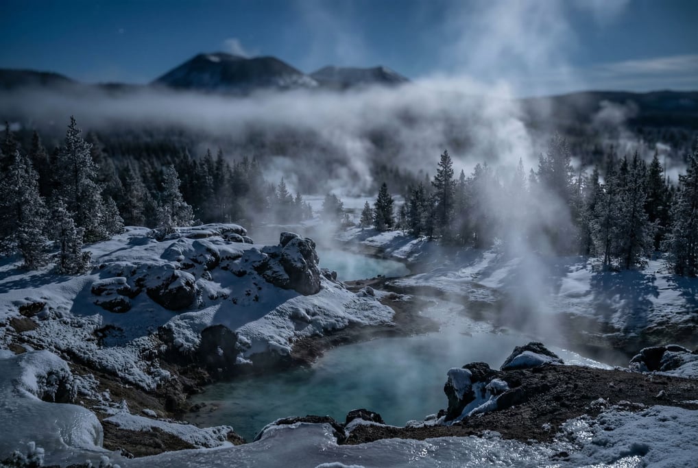 Snow-covered volcanic hot springs, steam rising from turquoise mineral pools into sub-zero air (ocohqpvt)