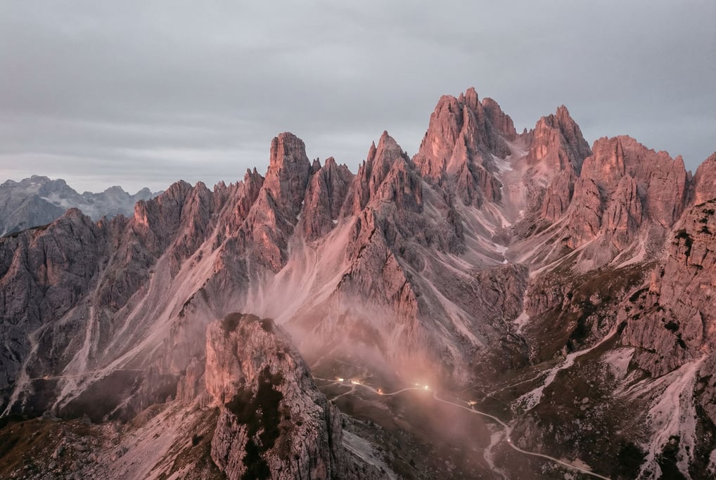 Dolomite towers glowing pink in alpenglow, vertical limestone pillars against a deep twilight sky (rfxjnyrc)